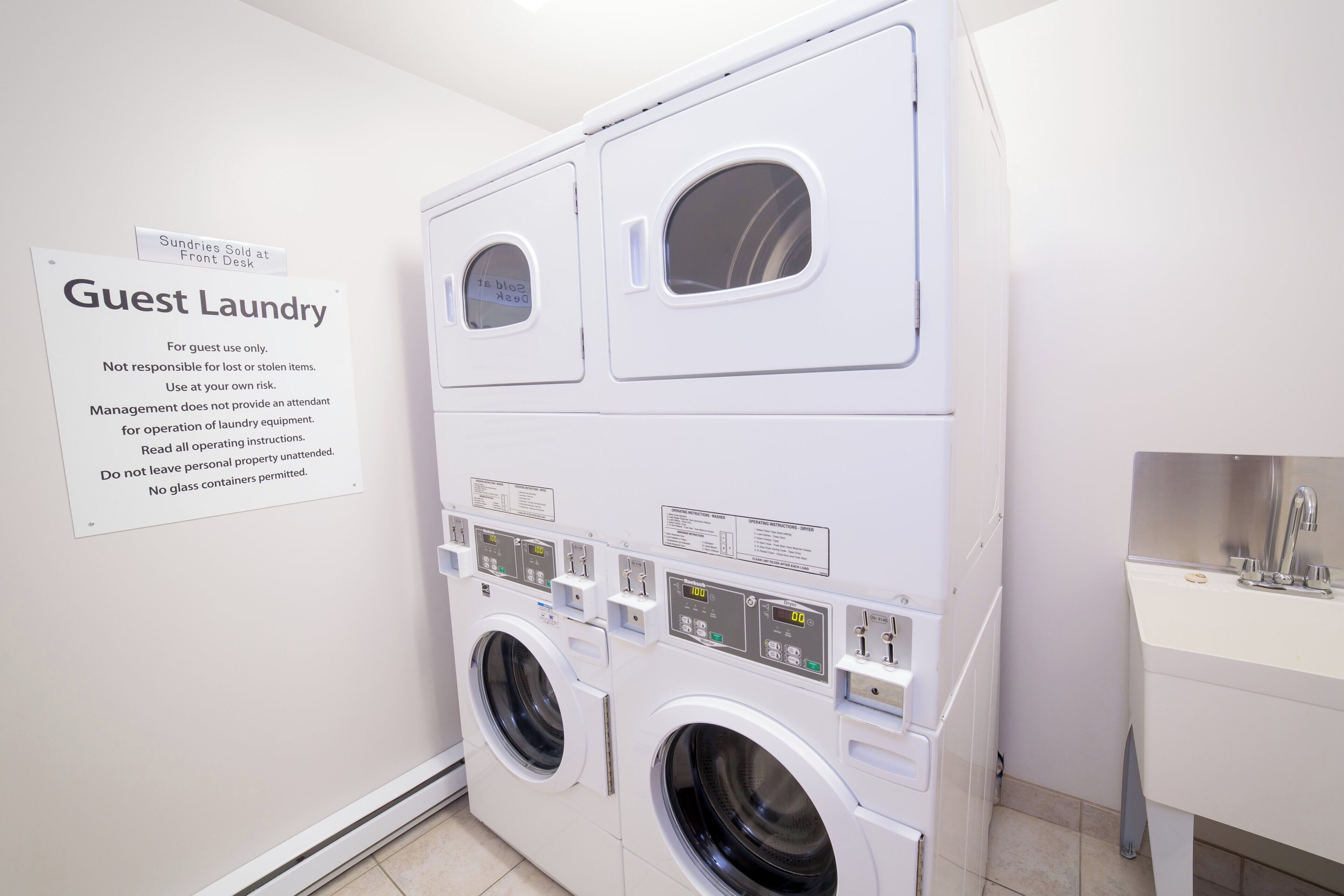 A guest laundry area with a sign indicating it's for guest use only, and instructions for operation.