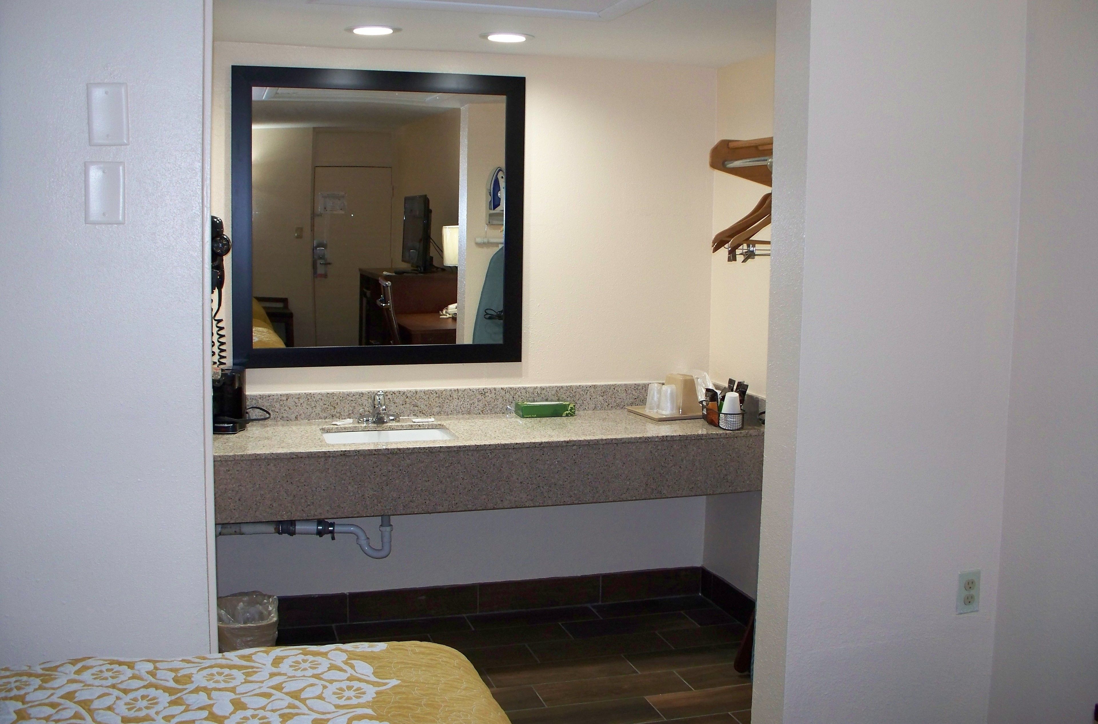 A bathroom with a sink, mirror, and towel rack.