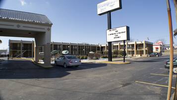 A Bluegrass Inn with a parking lot, a covered entrance, and a building with multiple windows.