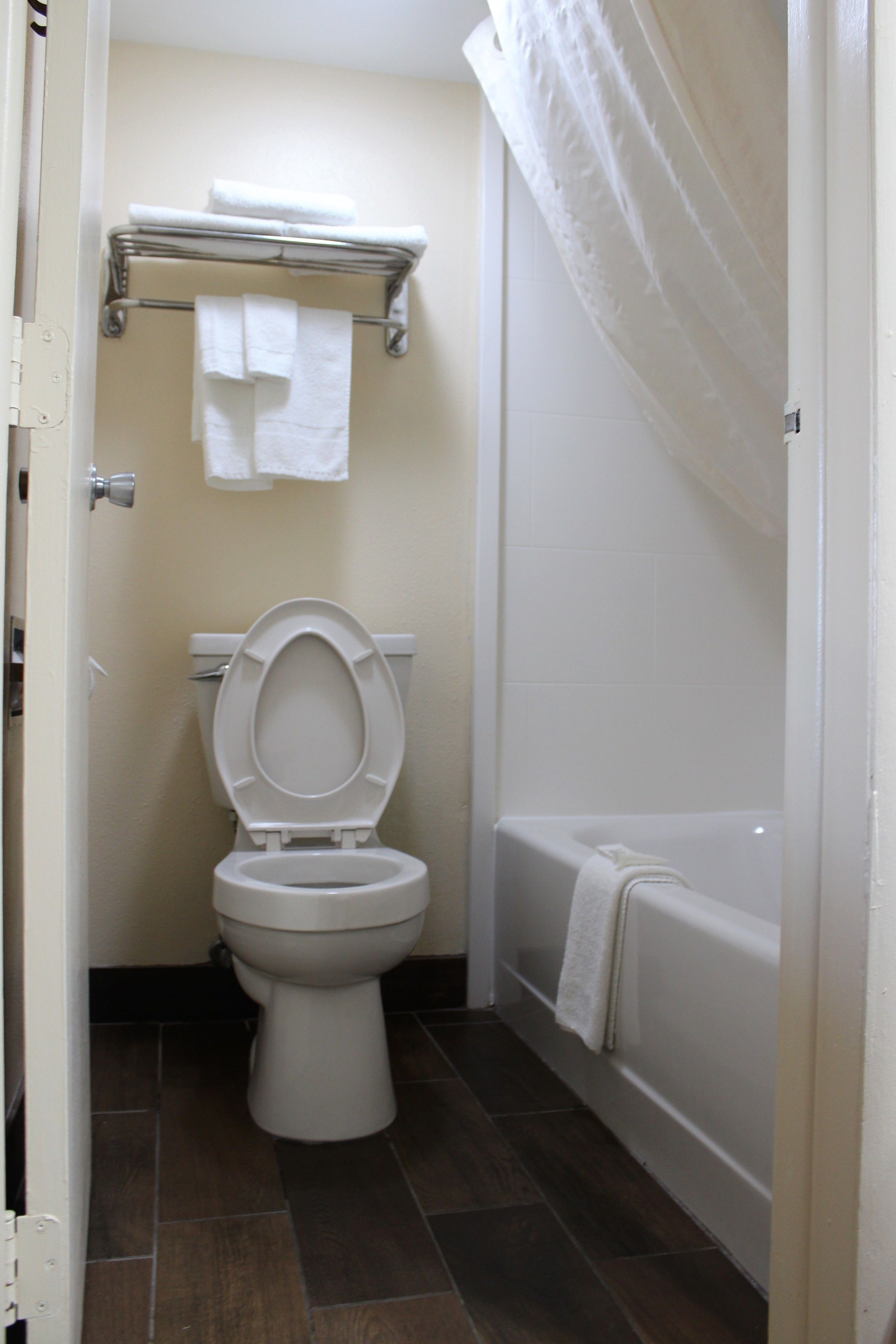 A bathroom with a toilet, a bathtub, and a shower curtain.