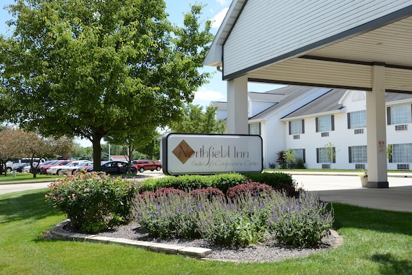 A Northfield Inn sign with a covered parking area and a landscaped garden in front.
