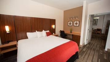 Een hotelkamer met een groot bed, een bureau en een stoel.