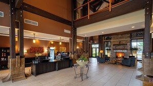 Un hall d’entrée spacieux avec un comptoir de réception, un coin salon et une cheminée.
