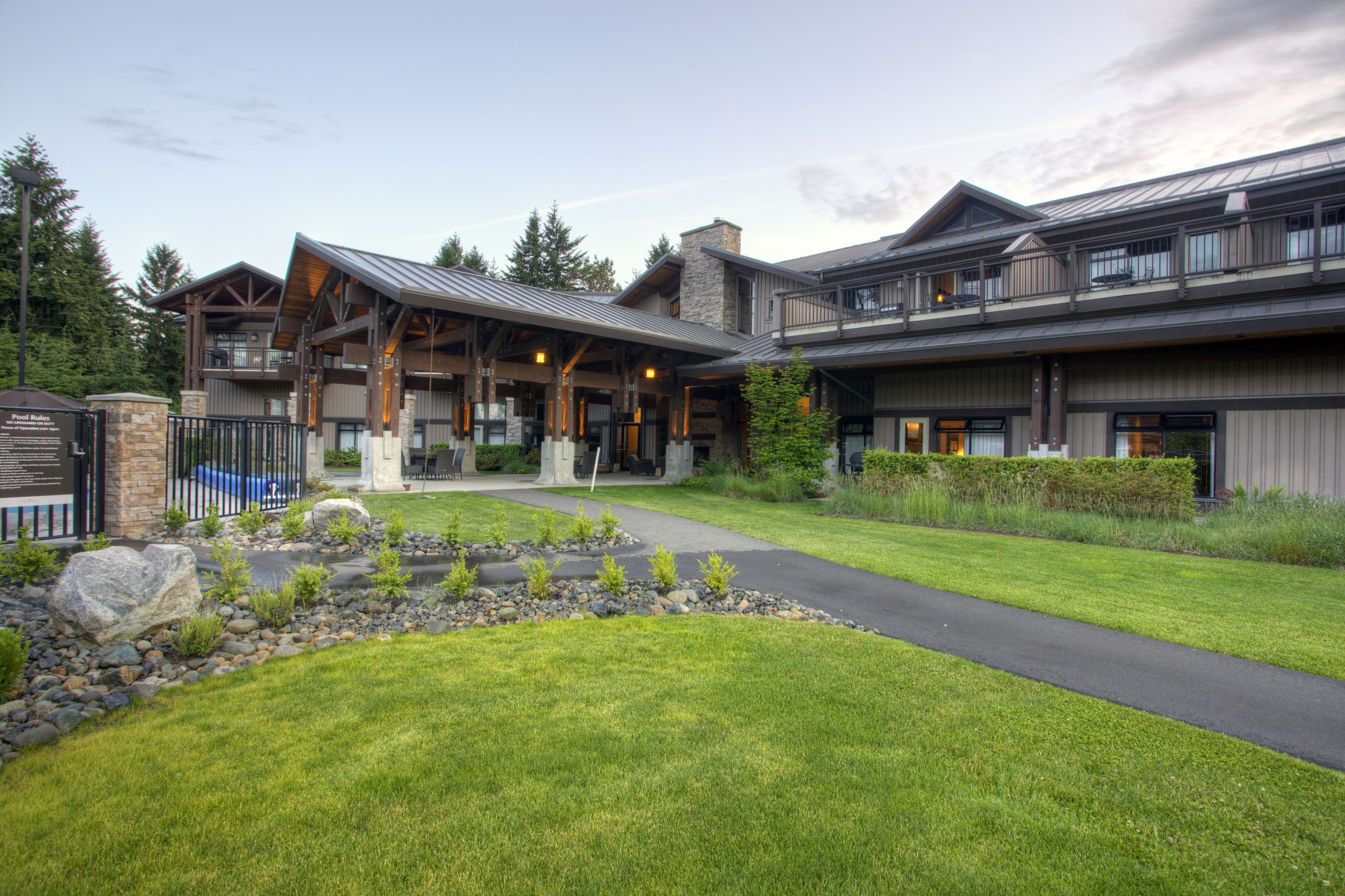 A large, multi-story building with a prominent entrance, stone pillars, and a well-maintained lawn.