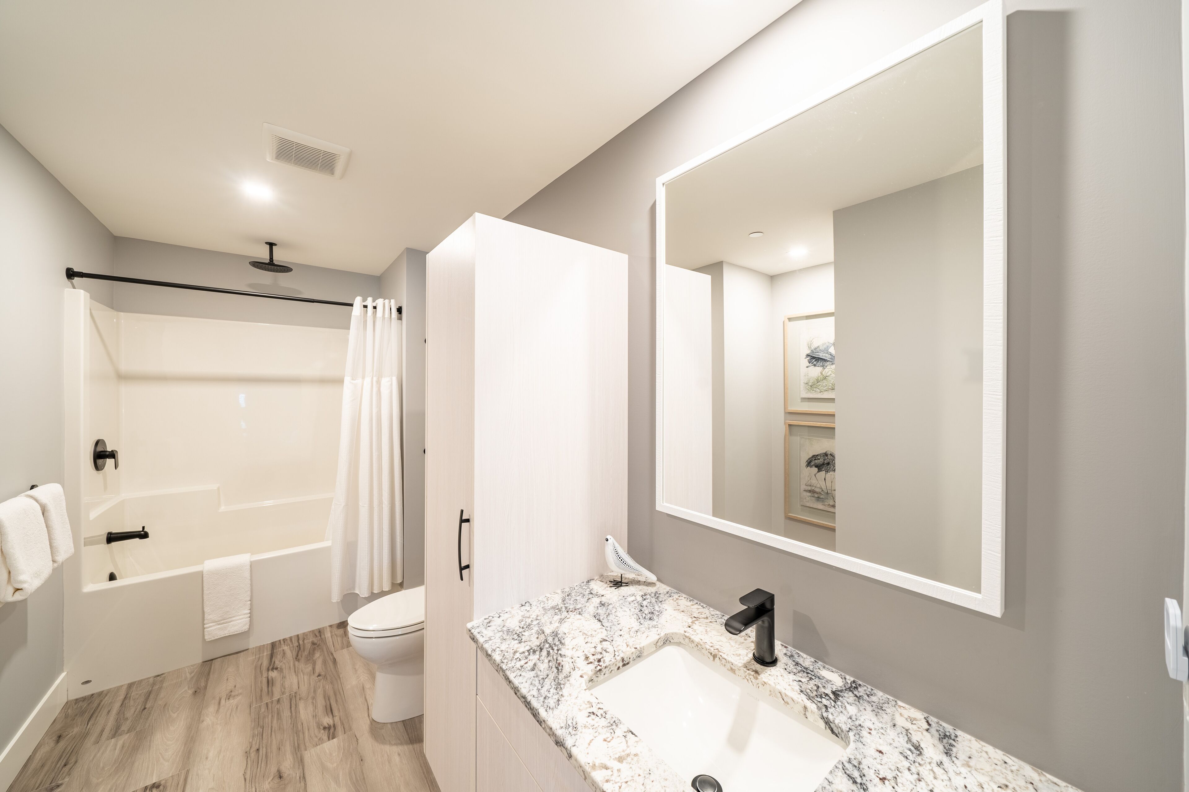 A modern bathroom with a bathtub, toilet, and sink.