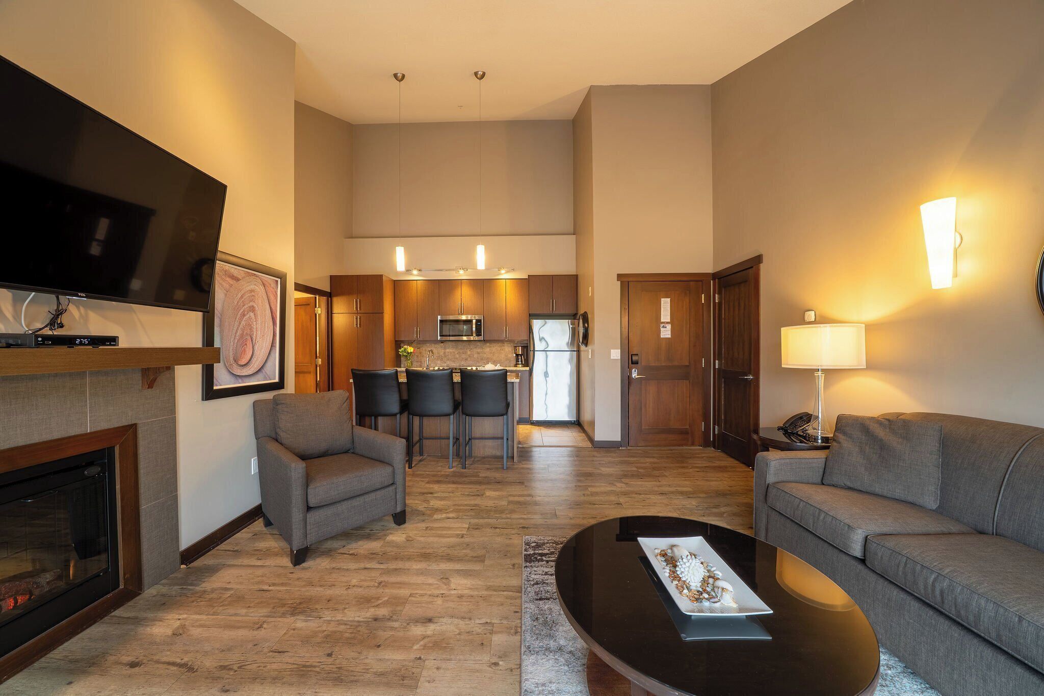 A modern living room with a fireplace, a flat-screen TV, a sofa, and a coffee table.