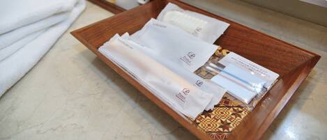 A tray with toiletries and towels on a bathroom counter.