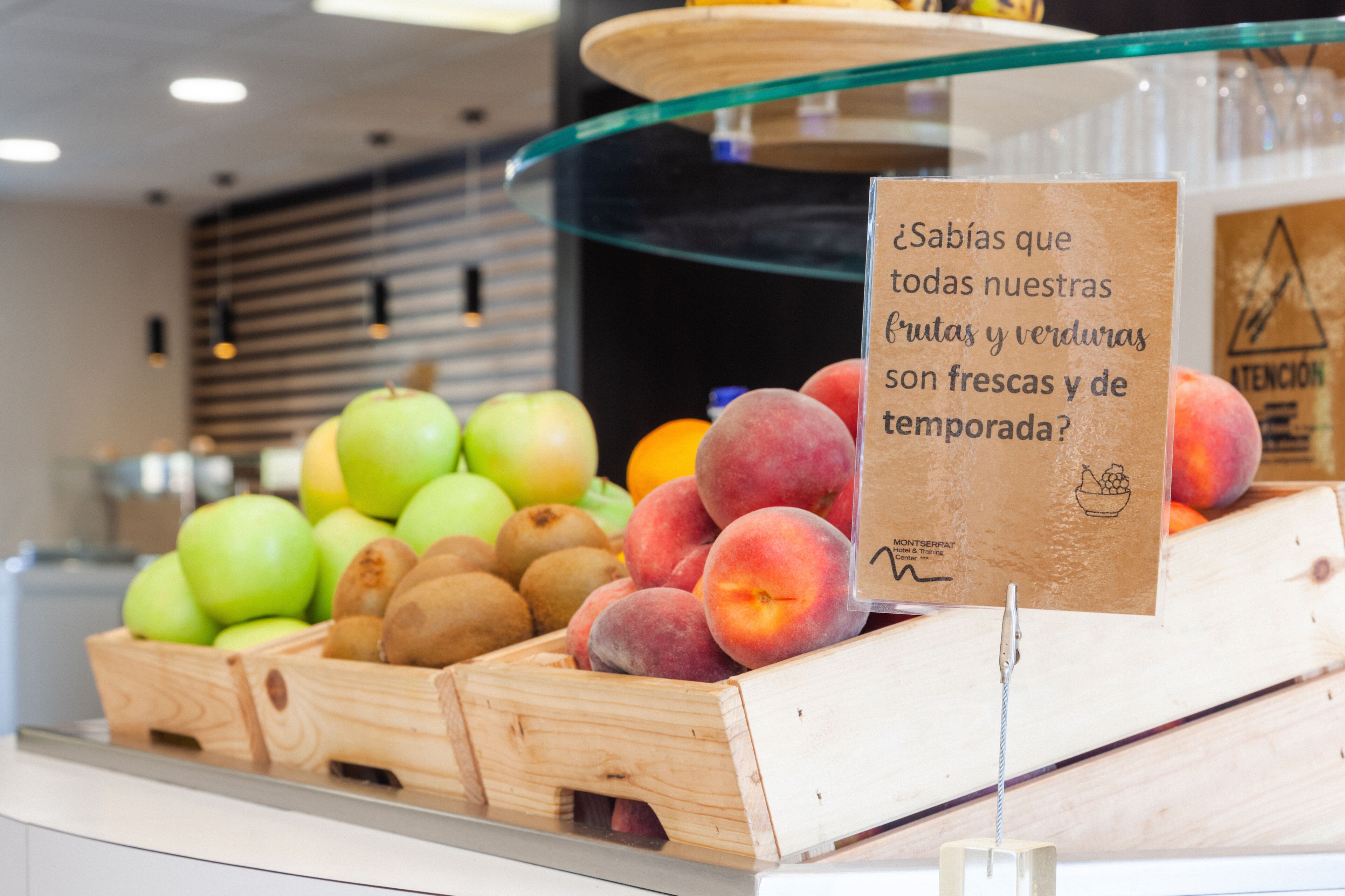 Presentació de fruita fresca, com ara pomes, préssecs i peres, en caixes de fusta.