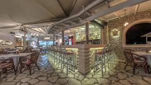 Ein Restaurant mit Steinböden, einer Bar und verschiedenen Sitzgelegenheiten.