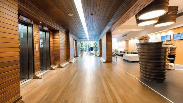 A modern hotel lobby with wooden paneling, a central corridor, and a reception area with a unique, stacked design. - Beyond Hotel - Boutique Class - Special Class (Izmir)