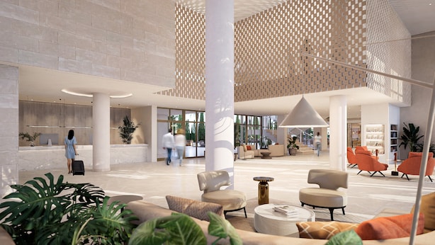 A spacious lobby with a modern design, featuring a reception desk, seating areas, and large windows.