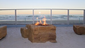 A stone fire pit with a view of the ocean. - Lotus Boutique Inn & Suites (Ormond Beach)