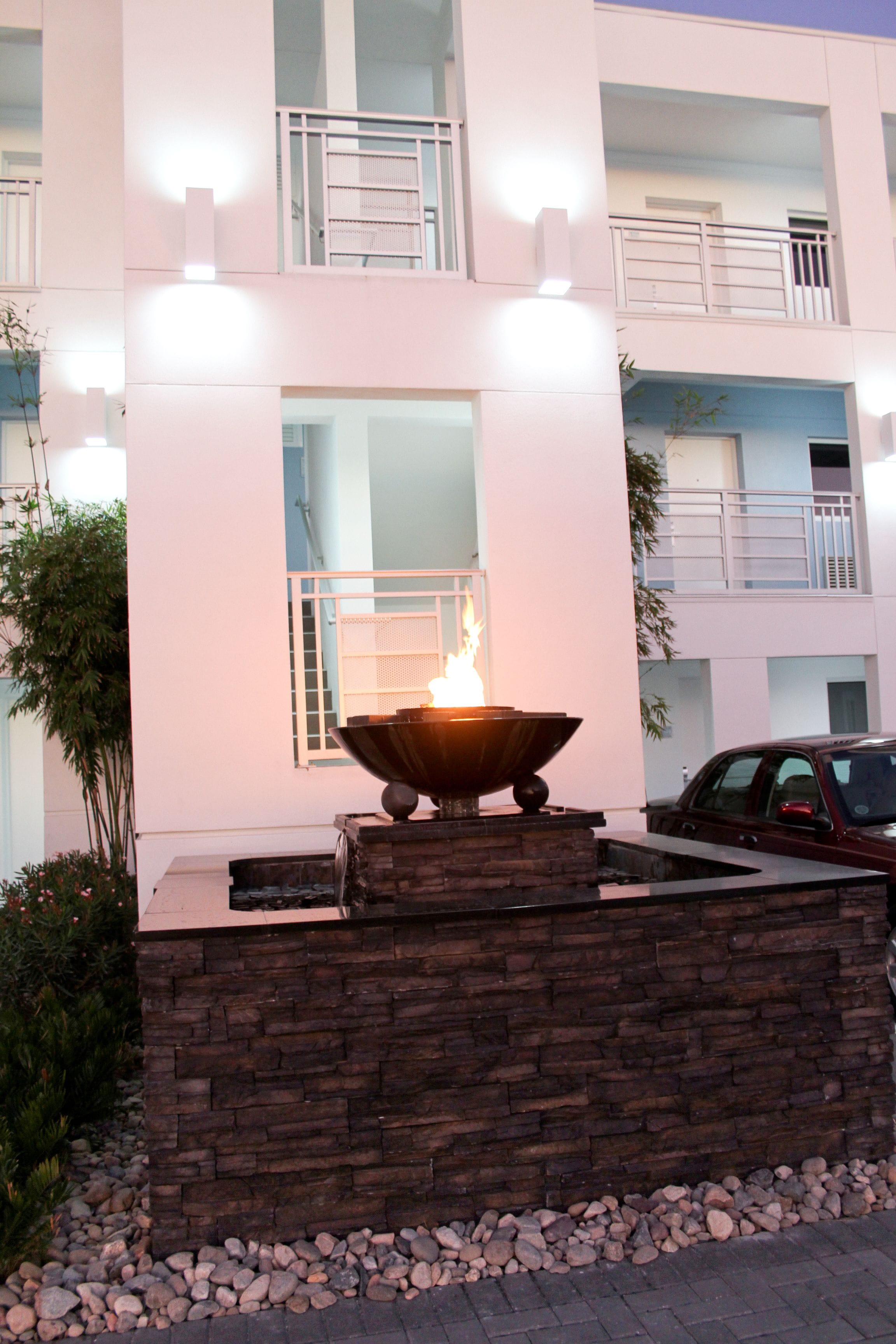 Un edificio moderno con un muro de piedra y una chimenea en el centro.