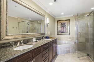 Un baño con un espejo grande, dos lavamanos, una bañera y una ducha con mampara de vidrio.