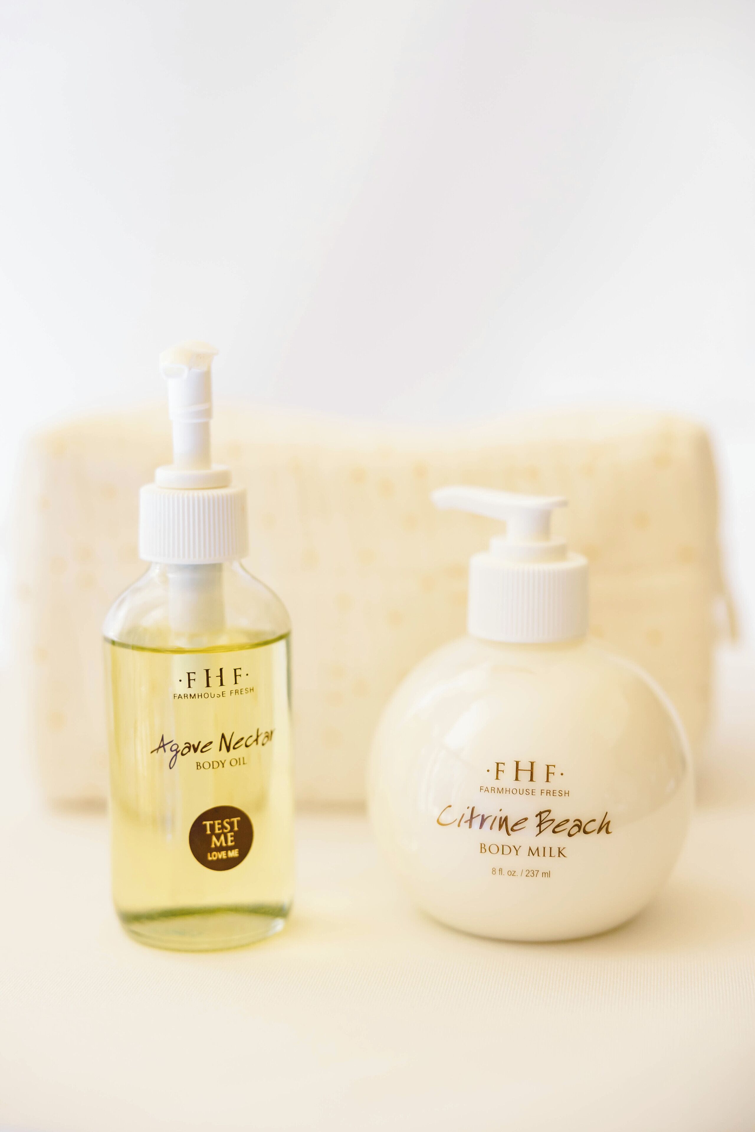 Two bottles of Farmhouse Fresh body products, one with a pump dispenser and the other with a pump top, placed on a white surface.