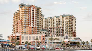 A waterfront hotel with multiple high-rise buildings, balconies, and a marina with boats.