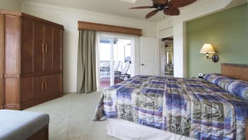 Ein Schlafzimmer mit einem großen Bett, einem Holzschrank, einem Deckenventilator und Blick ins Freie.
