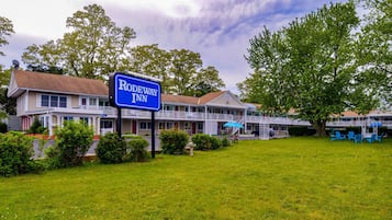 Guests can enjoy a serene setting surrounded by a well-maintained lawn and trees at this motel.