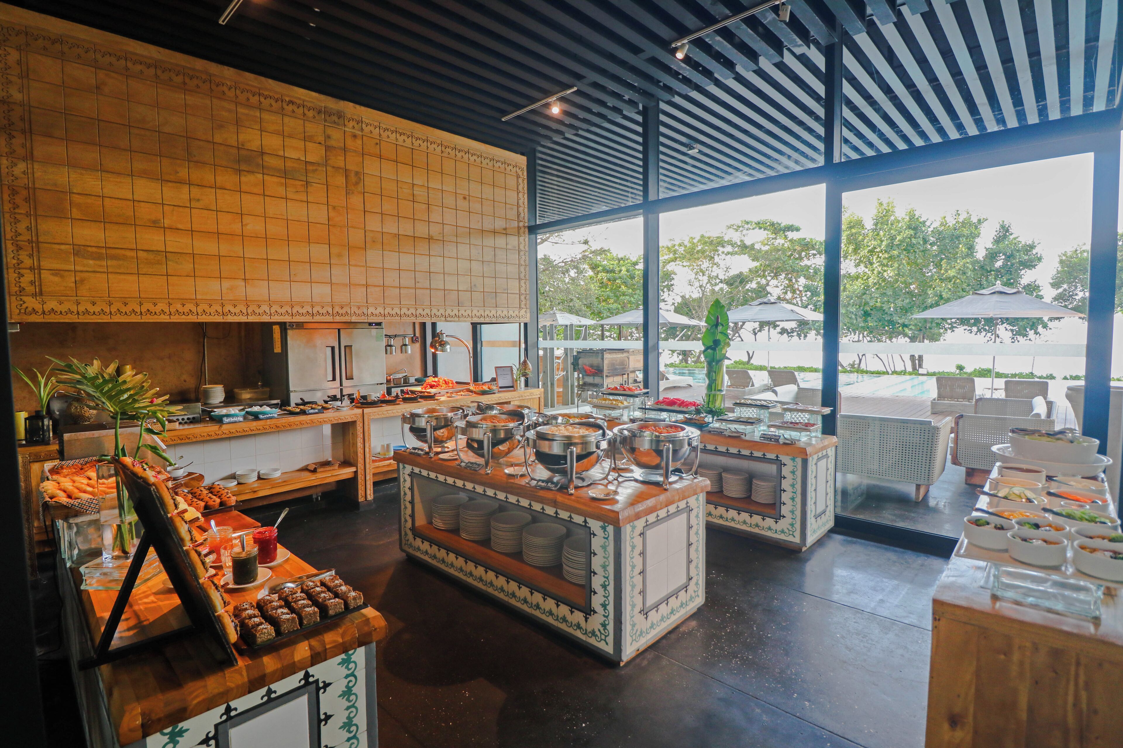 A buffet setup with various food stations, a seating area with outdoor views, and a modern interior design.