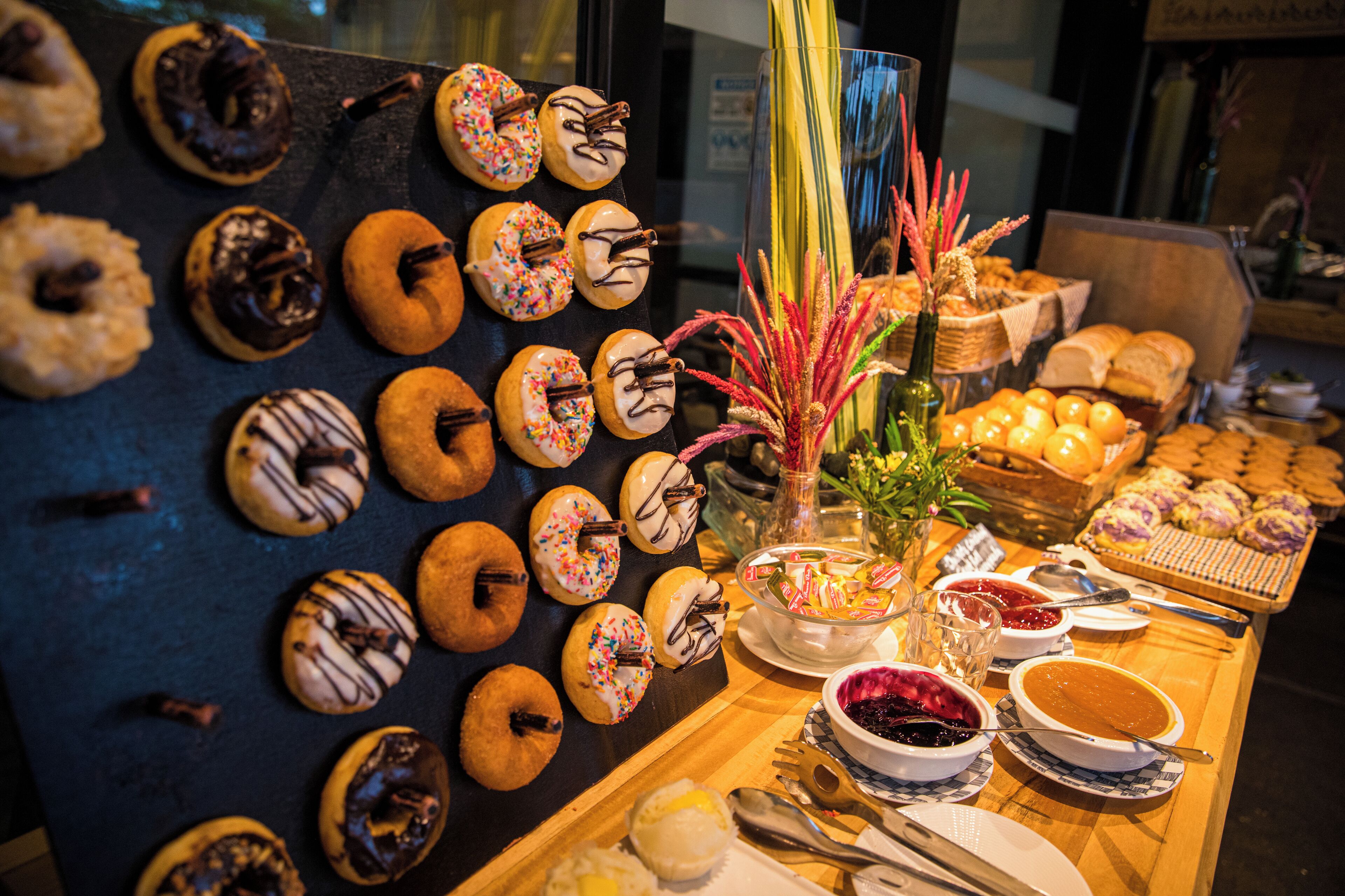 A display of various pastries and desserts, including donuts and cakes, arranged on a counter.