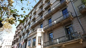 A multi-story building with balconies, large windows, and a classical architectural style. - Petit Palace Eixample (Barcelona)