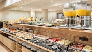 A buffet with various food items, including fruits, cheeses, meats, and beverages. - Petit Palace Eixample (Barcelona)