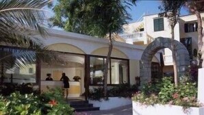 Un hotel moderno con un patio central, una zona de recepción y un arco de piedra.