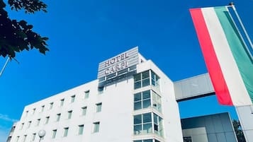 A modern hotel building with a sign reading "HOTEL CARP".
