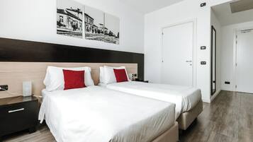 A modern hotel room with two beds, a wooden headboard, and a large window.