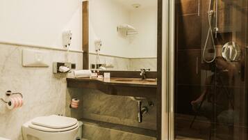 Ein modernes Badezimmer mit Toilette, Waschbecken und Dusche.