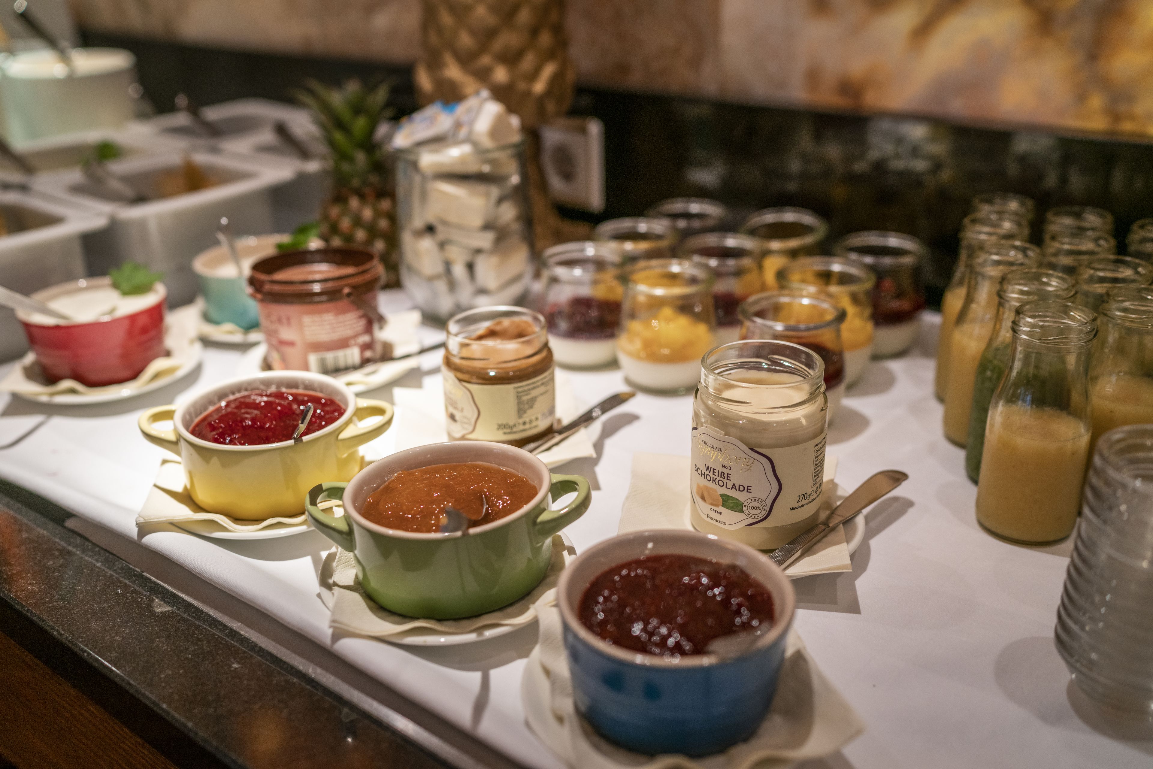 A buffet table with various food items and condiments.