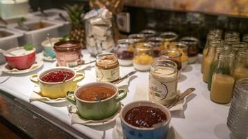 A buffet table with various food items and condiments.