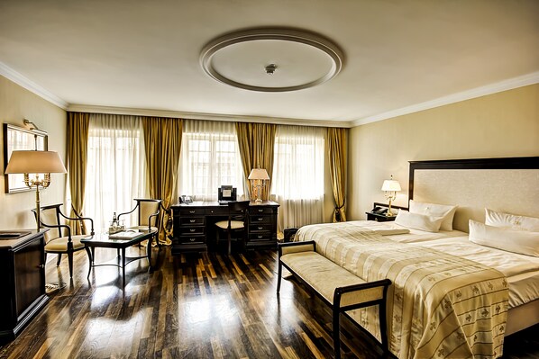 Una habitación de hotel con cama, escritorio, sillas y cómoda.