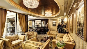 Un elegante vestíbulo de hotel con muebles ornamentados, candelabros y una zona de bar.