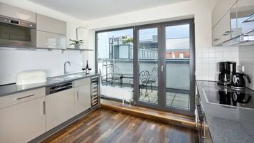 Eine moderne Küche mit Backofen, Spüle und Kaffeemaschine.