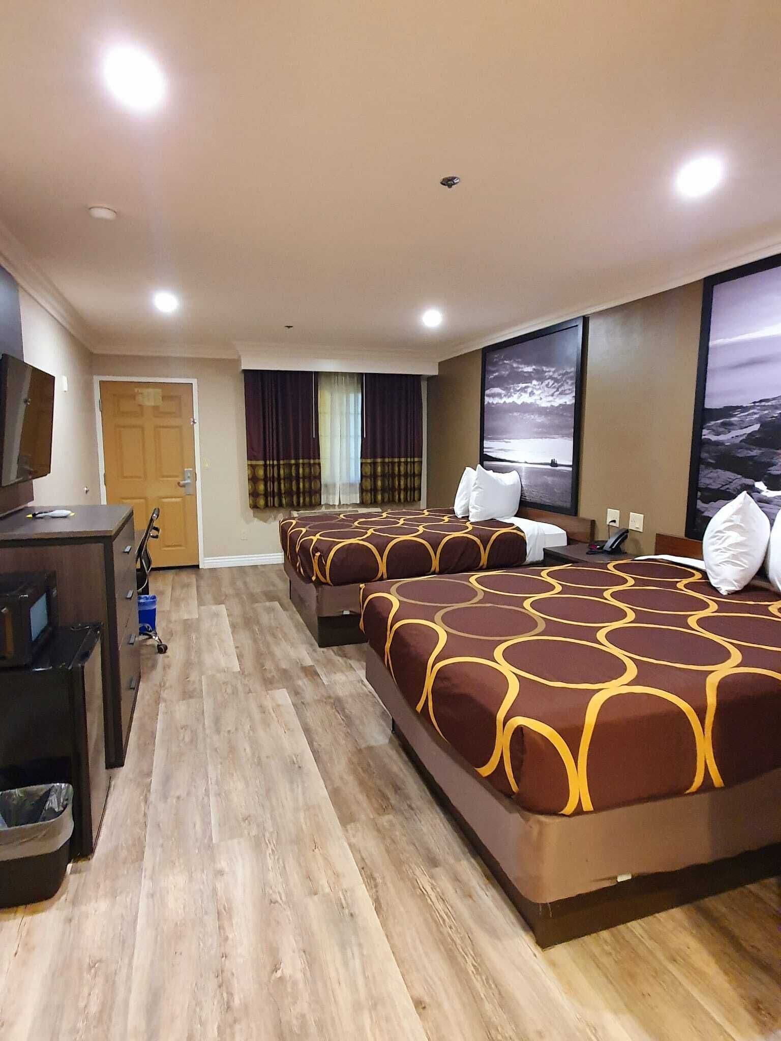 A hotel room with a large bed, a desk, and a television.