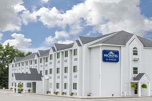 Experience the serene atmosphere of this charming hotel, featuring a central entrance with a covered porch and multiple windows and balconies.