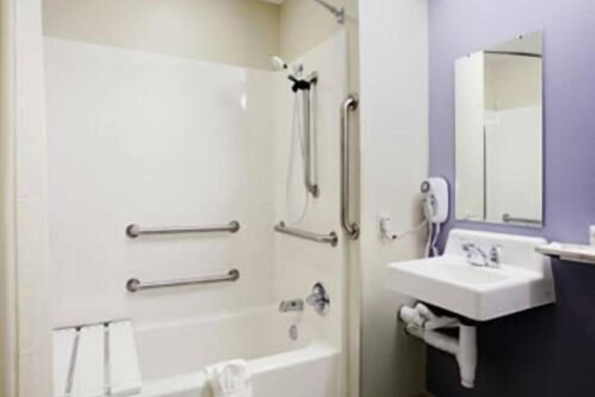 A bathroom with a bathtub, a shower, a sink, and a mirror.