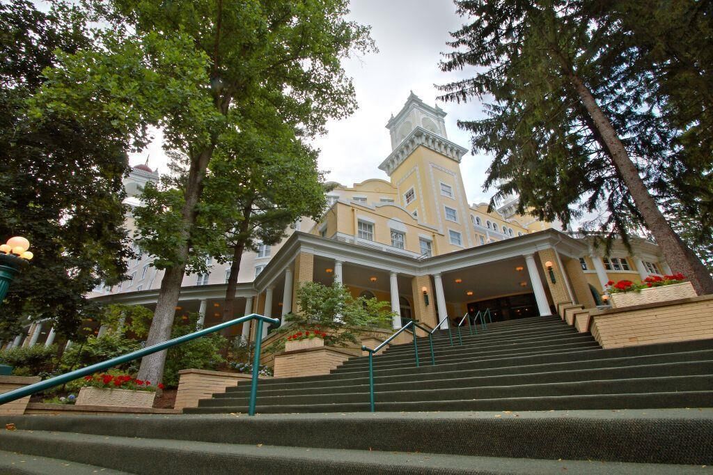 A building with a central tower, multiple windows, and a staircase leading to the entrance.