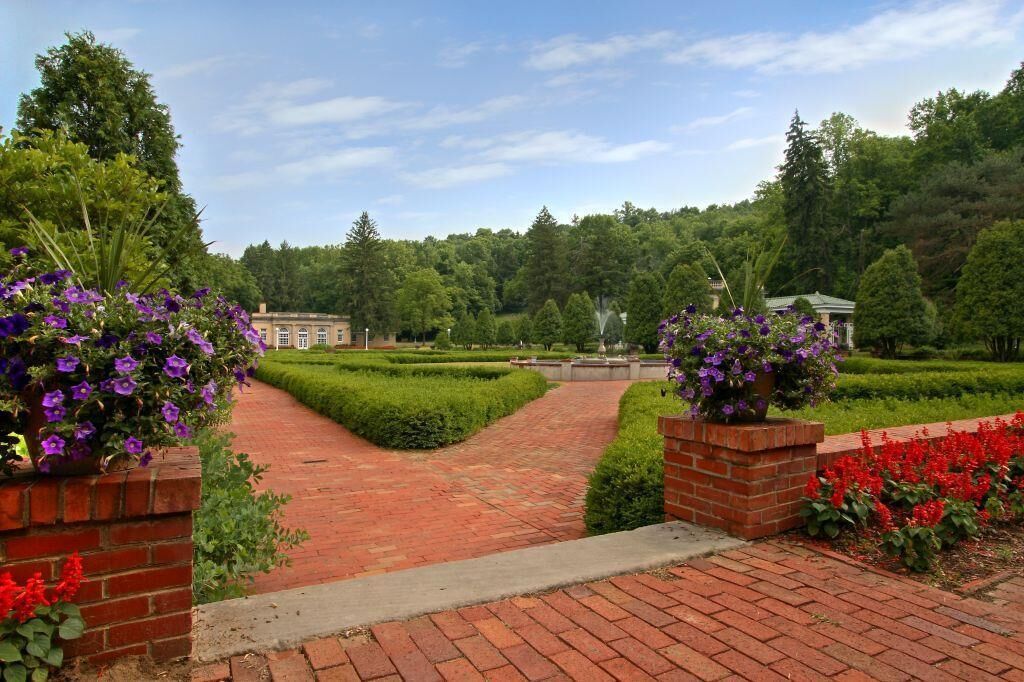 A landscaped garden with a brick pathway leading to a building.