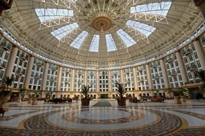 A grand, circular lobby with a high ceiling and large windows, featuring a central decorative element and multiple floors with balconies. - West Baden Springs Hotel (West Baden Springs)