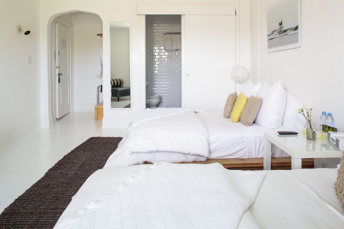 Une chambre moderne avec un grand lit, une table de chevet et une vue sur la salle de bain.