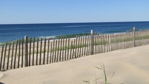 Een strand met een houten omheining en golven.