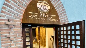Entrada de un spa con un arco de ladrillo y una puerta de madera.