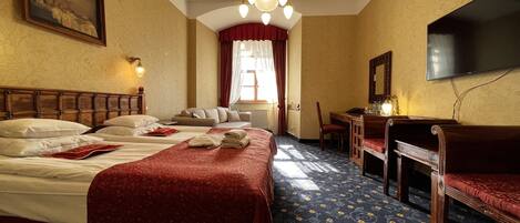 Une chambre d’hôtel avec un grand lit, un bureau, une chaise, une télévision et un lustre.