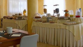 A breakfast buffet setup with various food items and beverages.