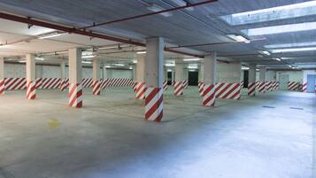A multi-level parking garage with striped barriers and directional arrows on the floor.