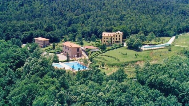 A large estate with multiple buildings surrounded by dense forest. There are several swimming pools visible. - Hotel Residence Sant'Uberto (Roccastrada)