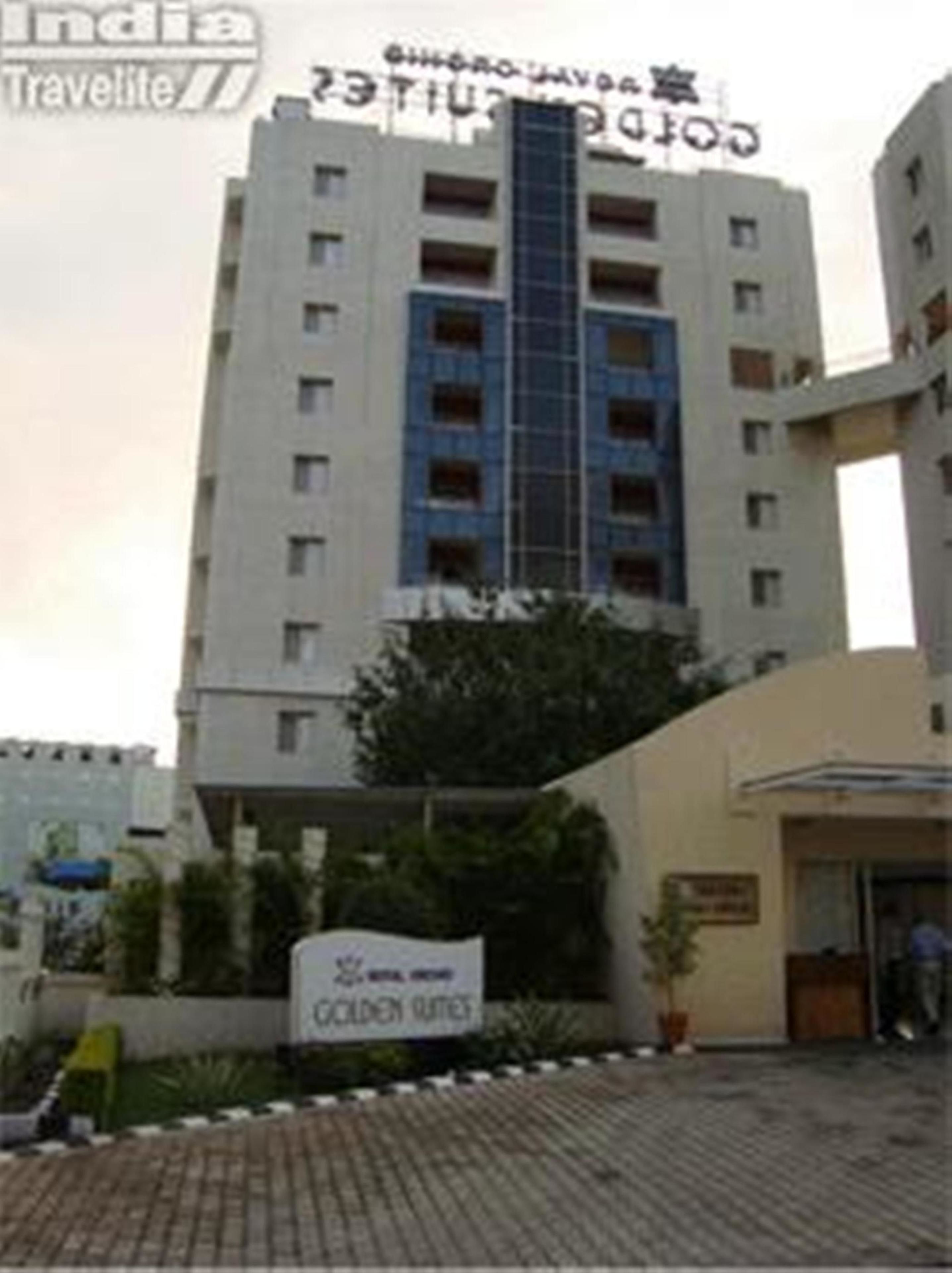 A multi-story hotel with a sign for "Golden Suites" and a "Travellite" logo.