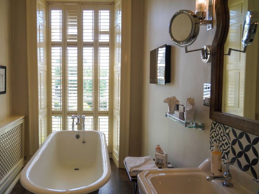 A bathroom with a bathtub, a sink, and a mirror.